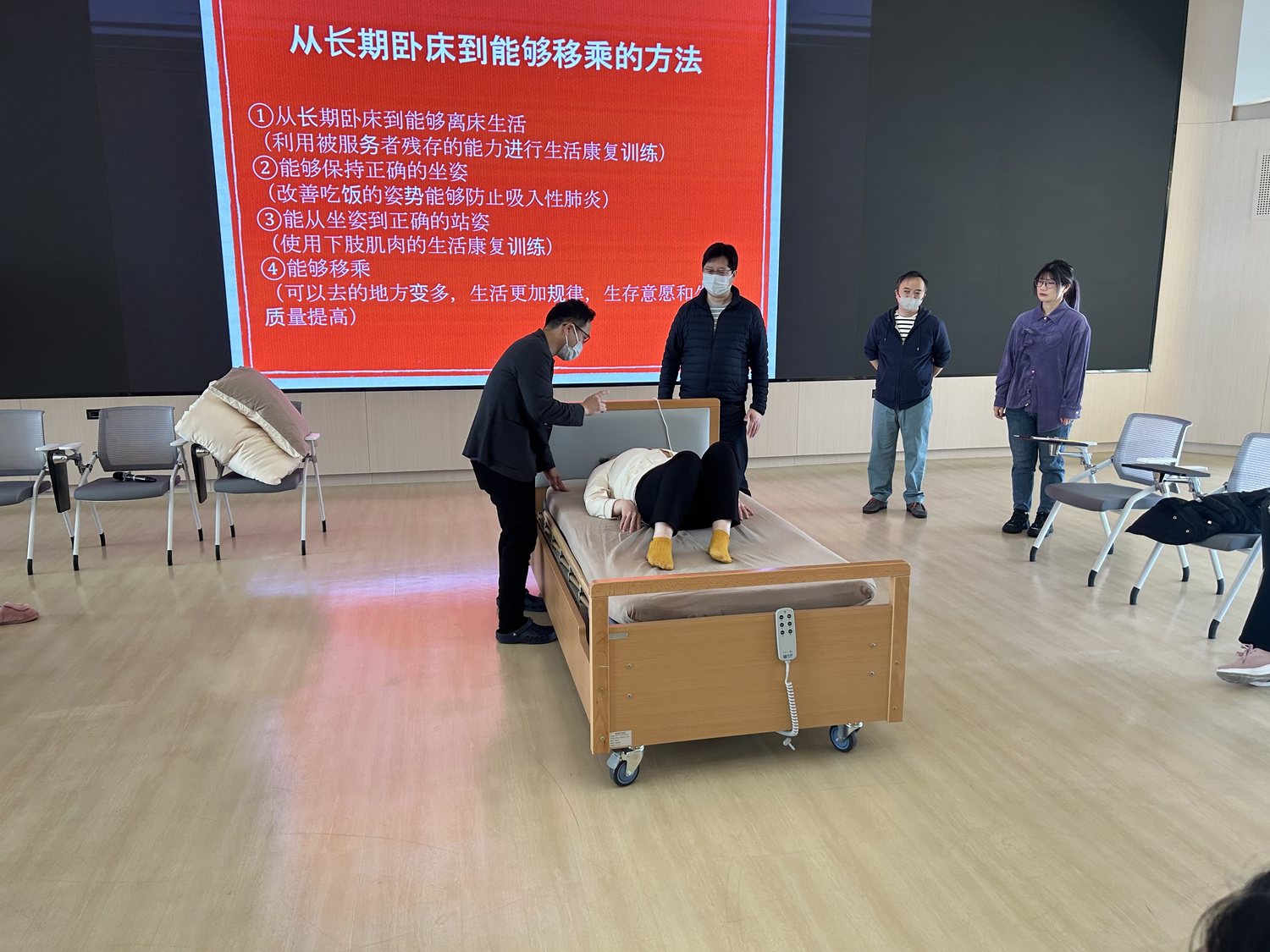 合掌苑讲师在床旁示范移乘动作